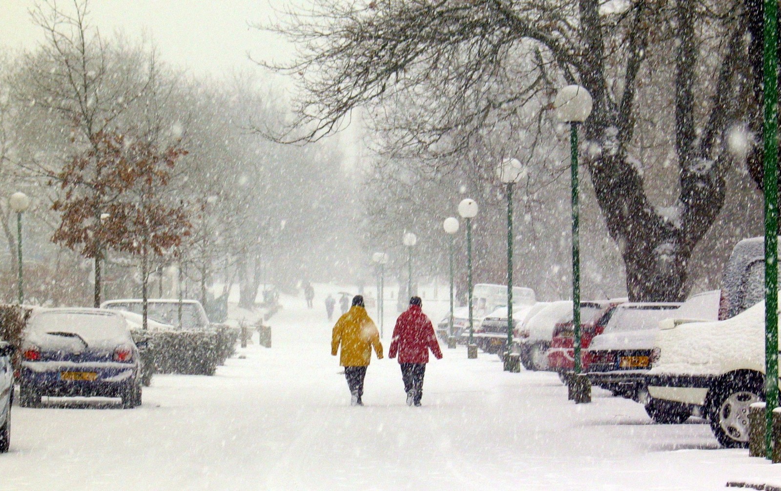Pedestrians walk on a street after heavy snowfall in Nantes, western France January 28, 2006. Cold weather conditions prevail in France since the beginning of the week, with snowfall and icy conditions in many parts of the country. REUTERS/Daniel Joubert